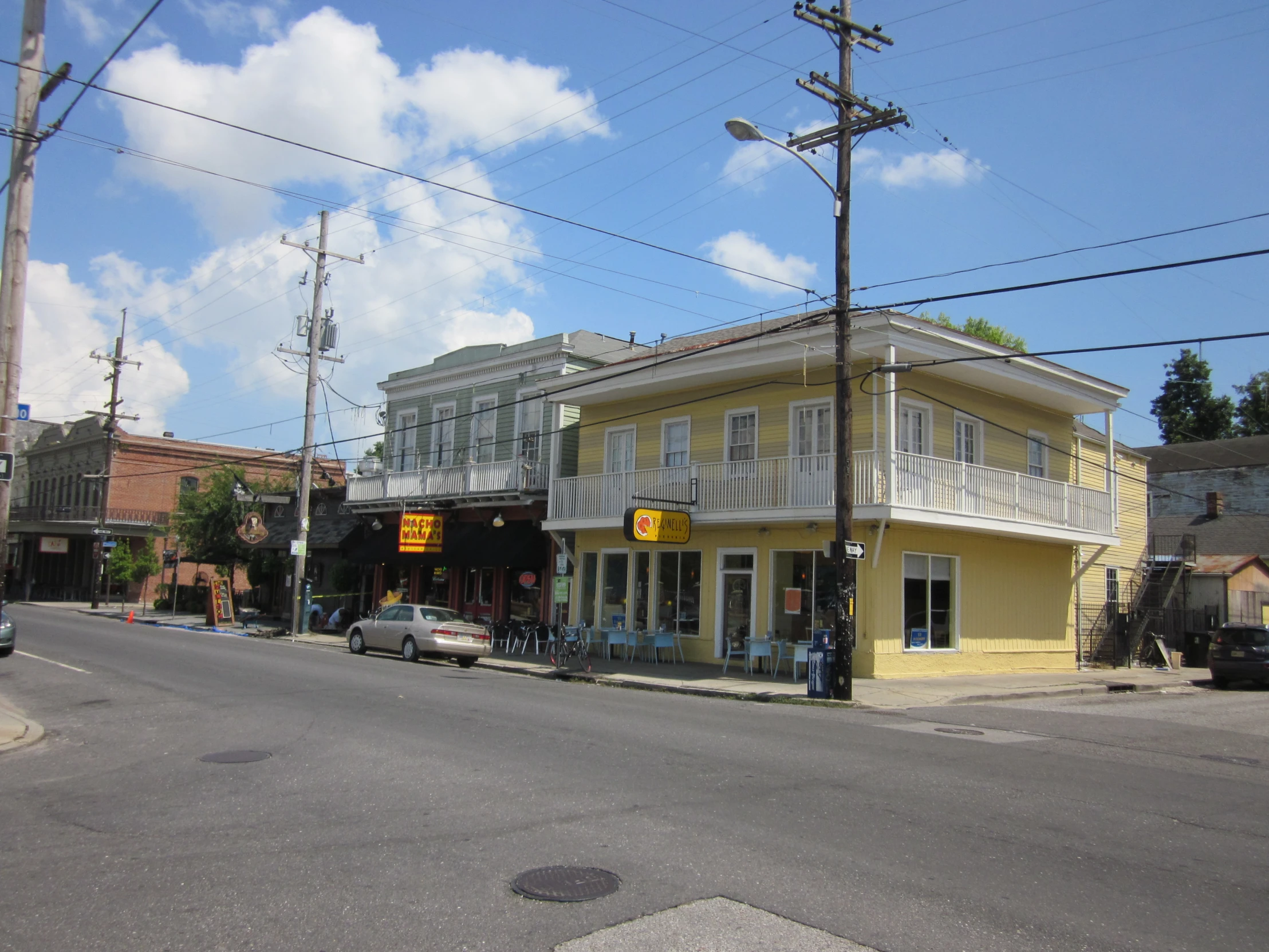 an old street scene of a yellow building in the middle of town