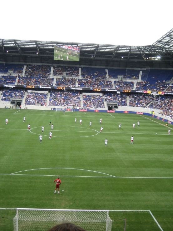 many people playing soccer in the middle of a large field