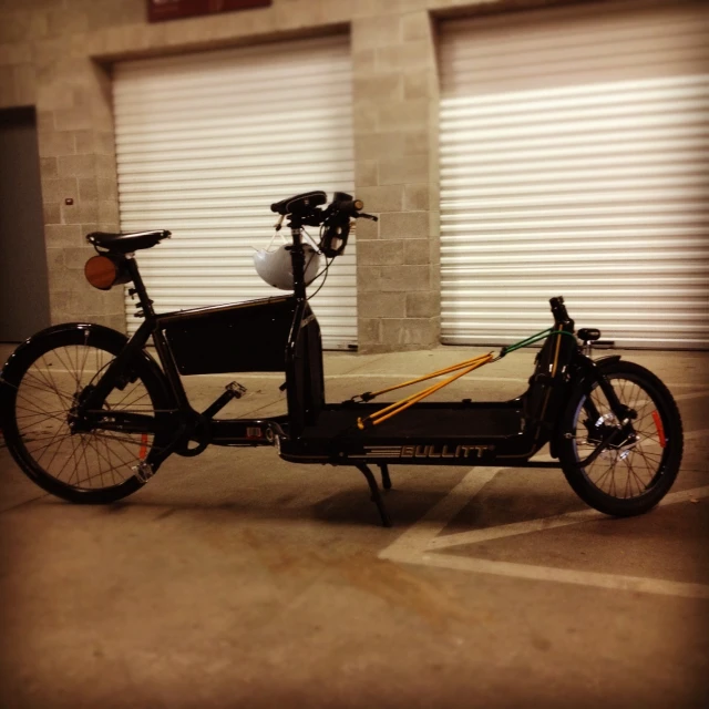 an empty motorcycle in a parking lot next to two roller door