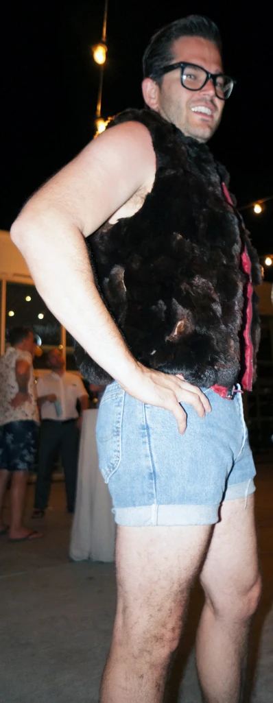 a man wearing a fake furry vest standing up