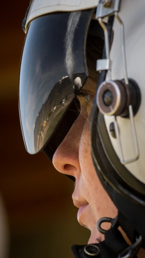 an equestrian looking into the side mirror and eye patch
