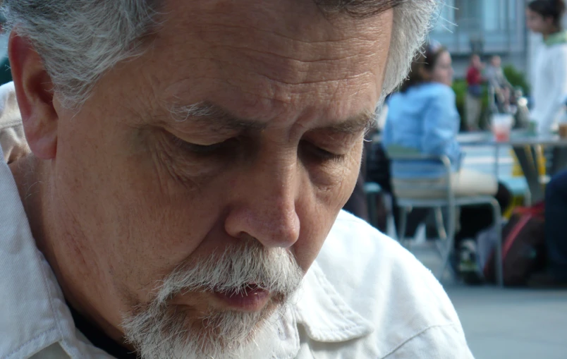 a man with a white beard looking down