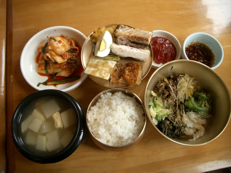 bowls filled with different foods on a wooden table