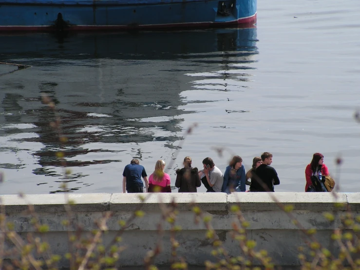 a group of people on a wall and a large boat