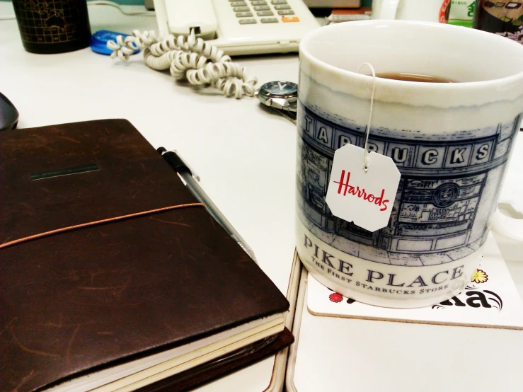 a small book sitting on top of a desk near a cup of coffee