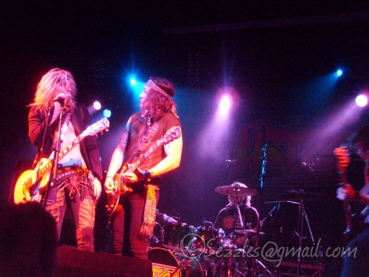 guitarists on stage with spotlights during a concert