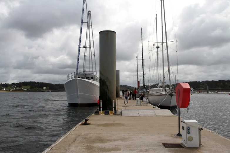 a very tall ship sitting at a dock next to a boat ramp