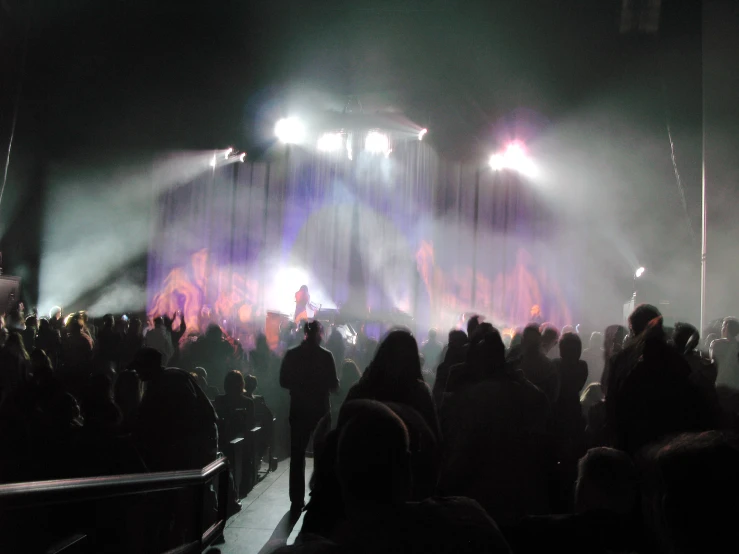 a crowd of people with lights and fog on a stage