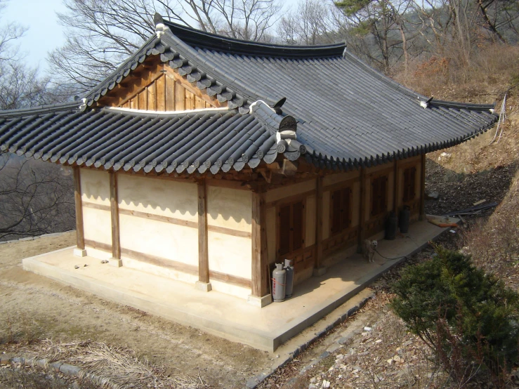 a small building with a tiled roof in the mountainside