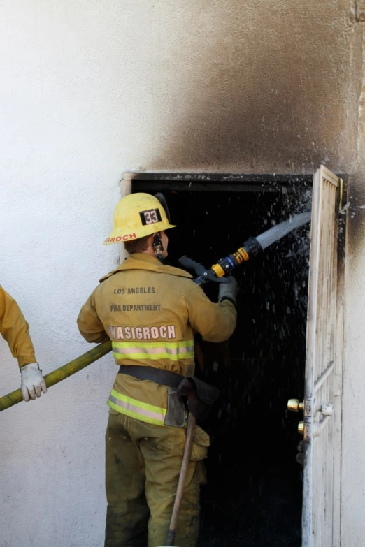 two fire fighters doing work on a fire escape door