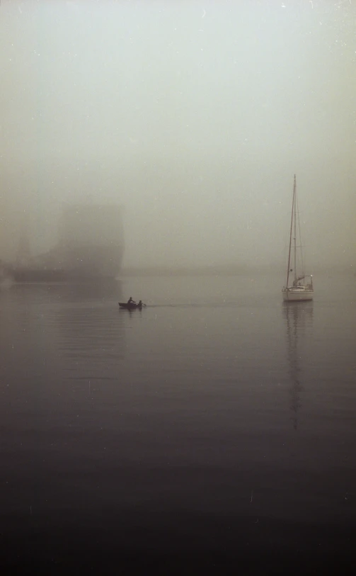 a small boat traveling on the ocean in a fog