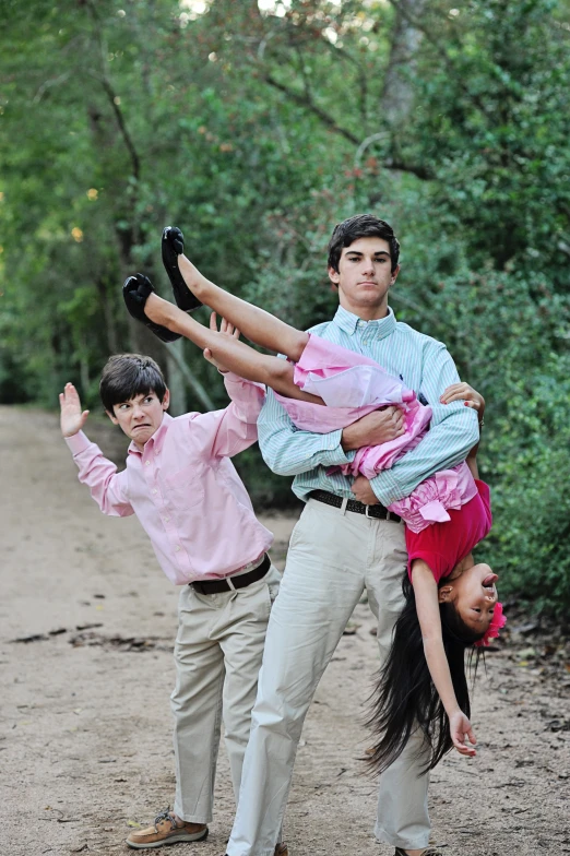 three people are upside down while standing in a field