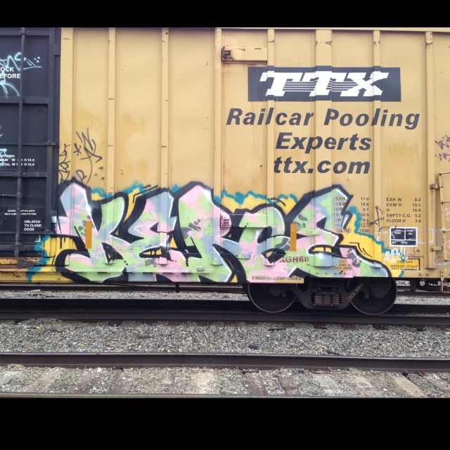 a train with graffiti sitting on some train tracks