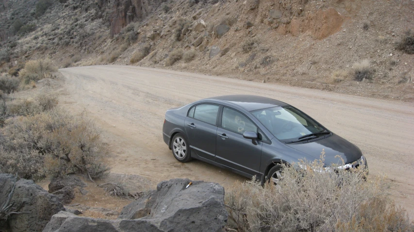 an automobile that is parked on a dirt road