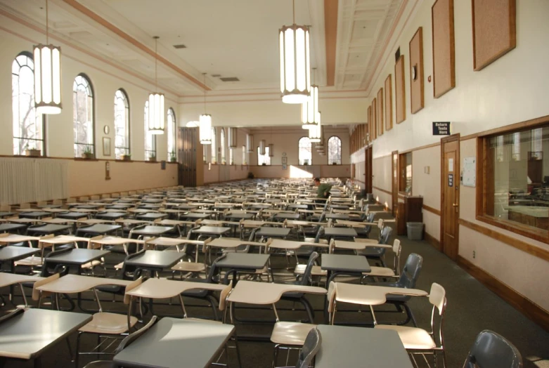 a large empty school room with desks and windows