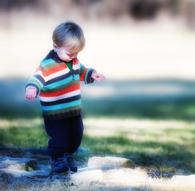 a  in striped shirt standing next to an object