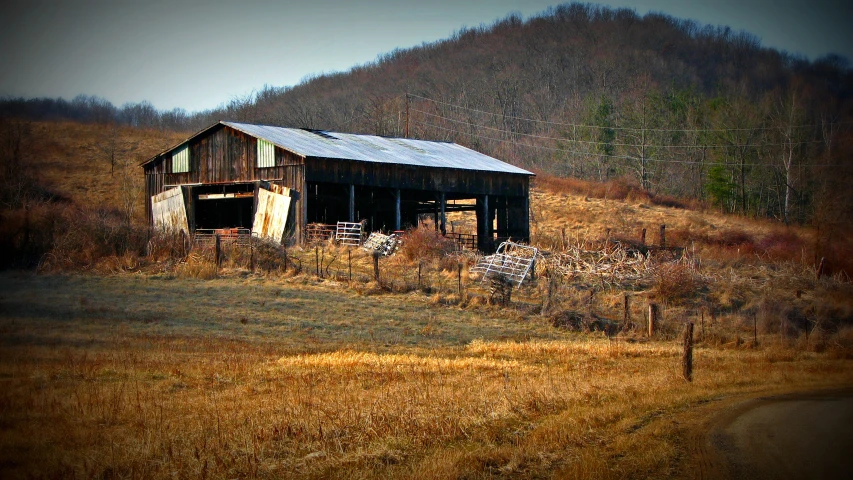 an old rundown barn sits in a field