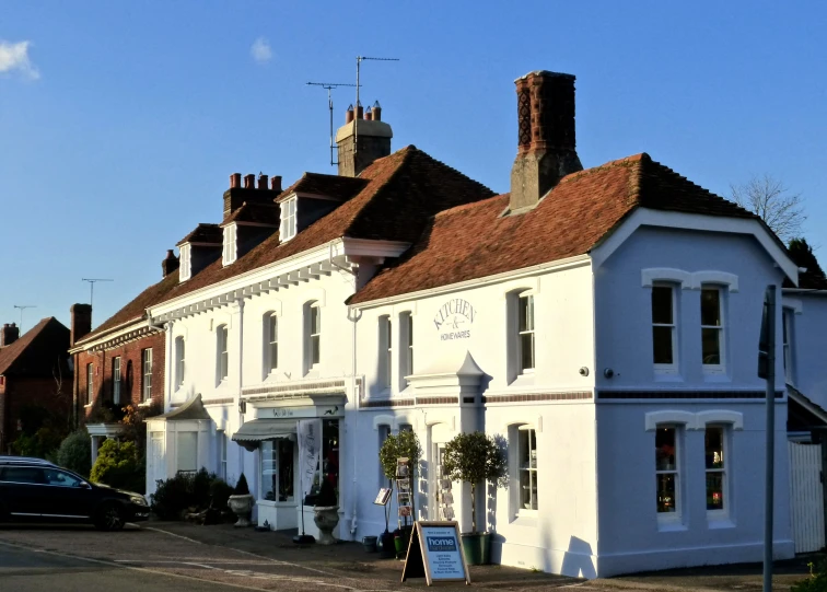 a tall white building on the corner in front of a road