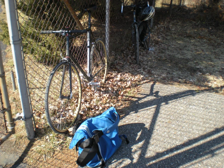 a back pack next to a parked bicycle on the street