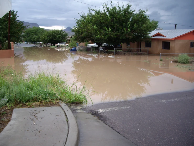 flooded street with house with cars on street