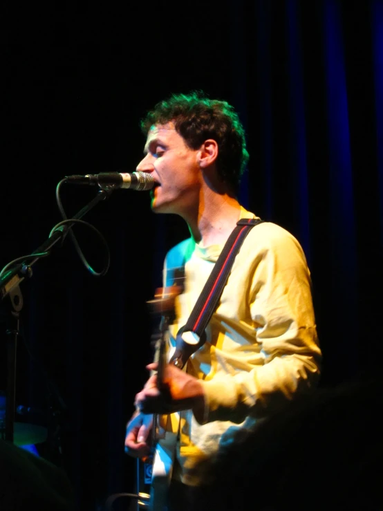 there is a young man singing into a microphone