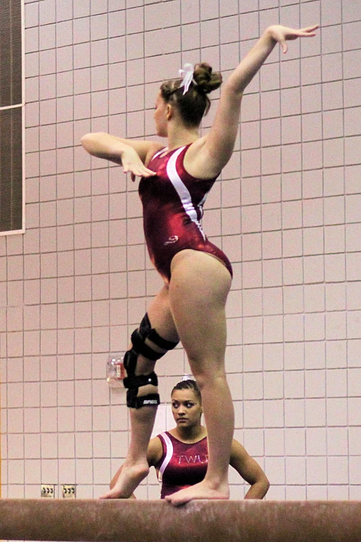 two young women doing gymnastics on a balance beam