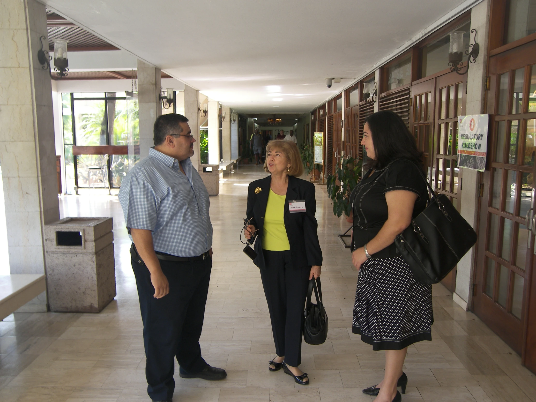 three people standing outside the building talking