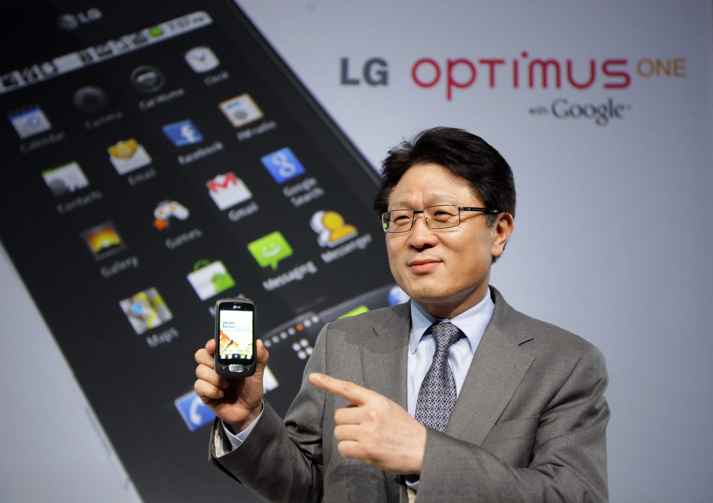 a man in a suit holds up his cell phone