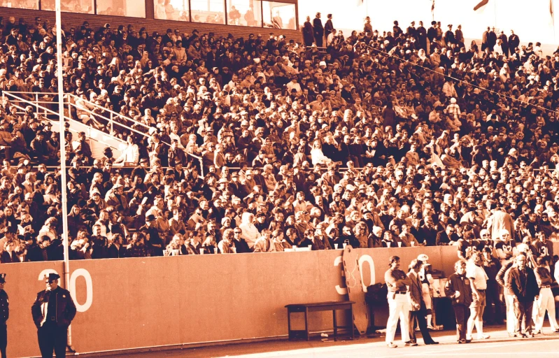 a brown and white po of people in an old baseball stadium