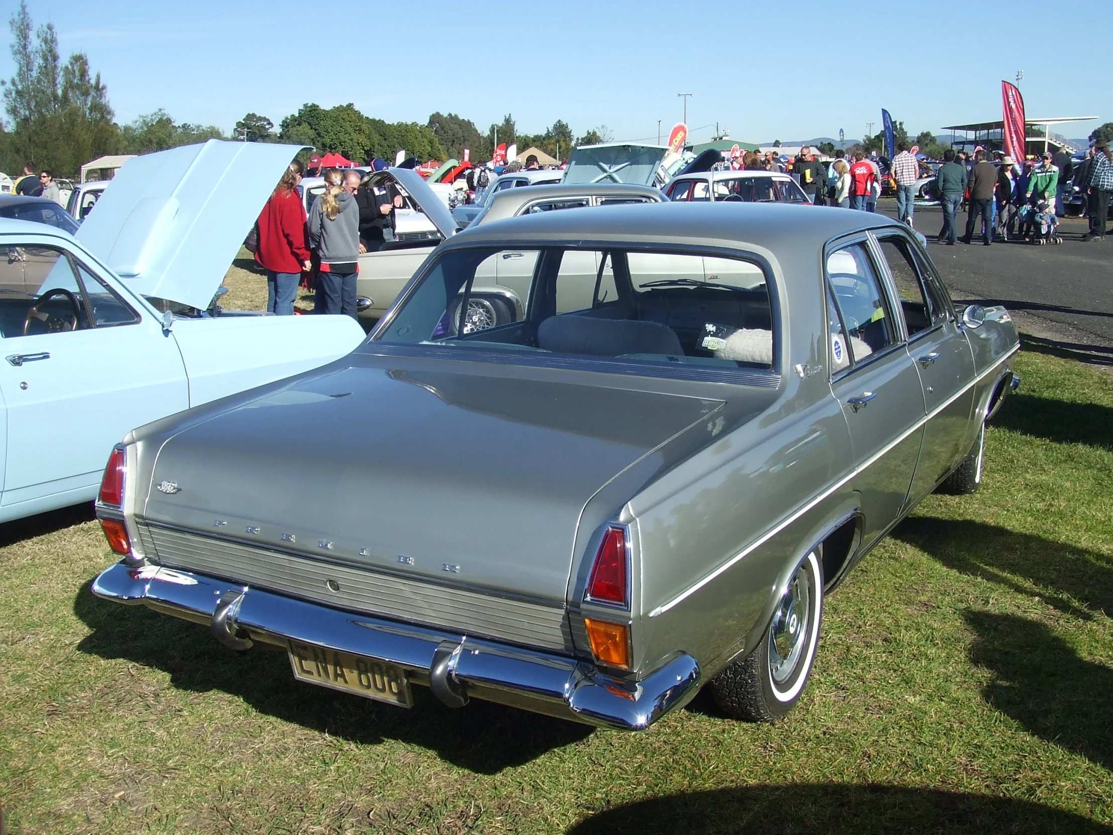 several vintage cars in a grassy area at an event