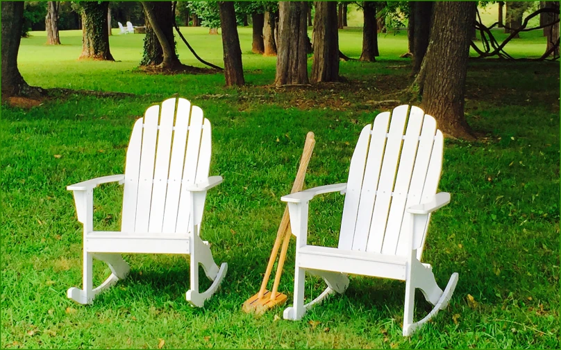 two chairs sitting in the grass on top of a field