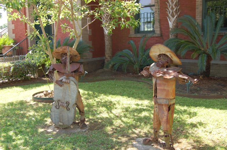 a couple of wooden statues sitting in the grass