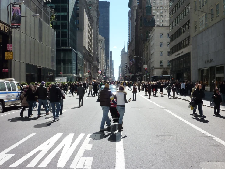 people on a street with cars and buses in traffic