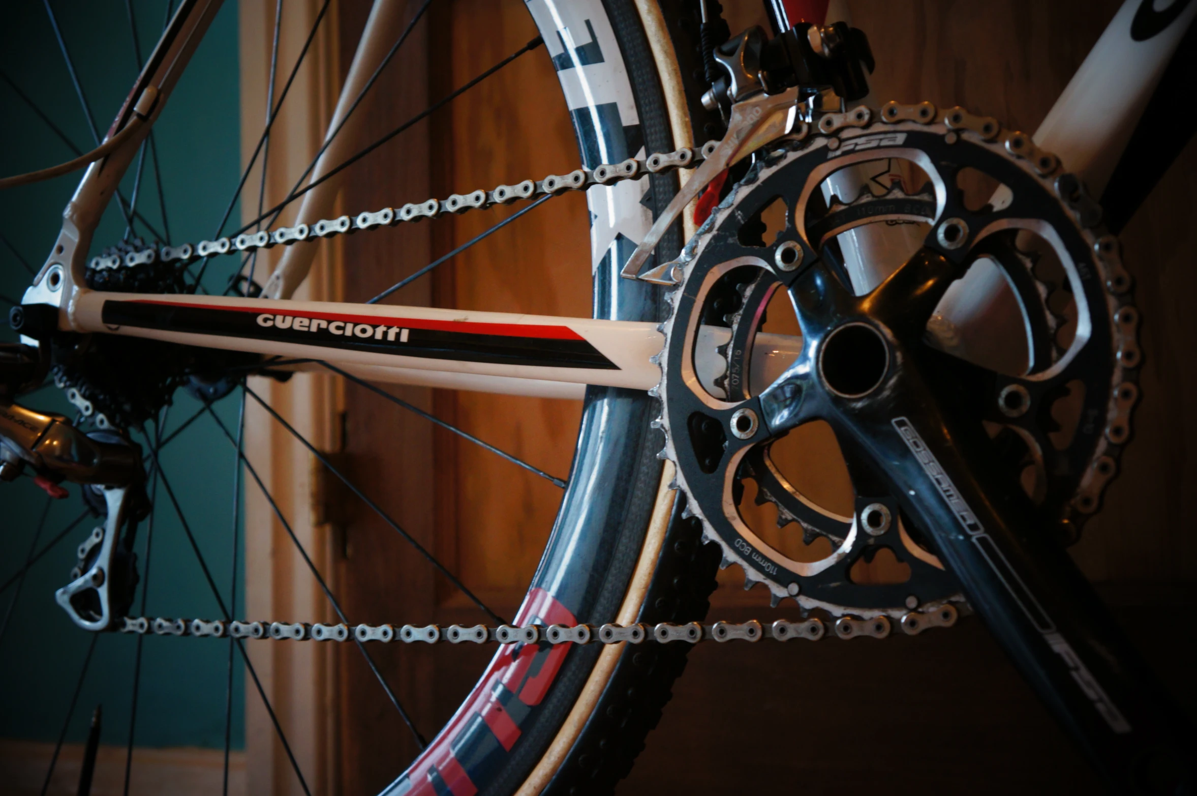 a bicycle parked near a wooden door with a chain hanging from the front wheel