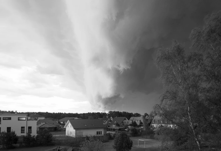 black and white pograph of storm clouds over houses