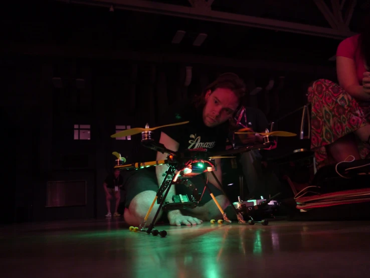 a man sits on the ground while playing with a kit and music pedal