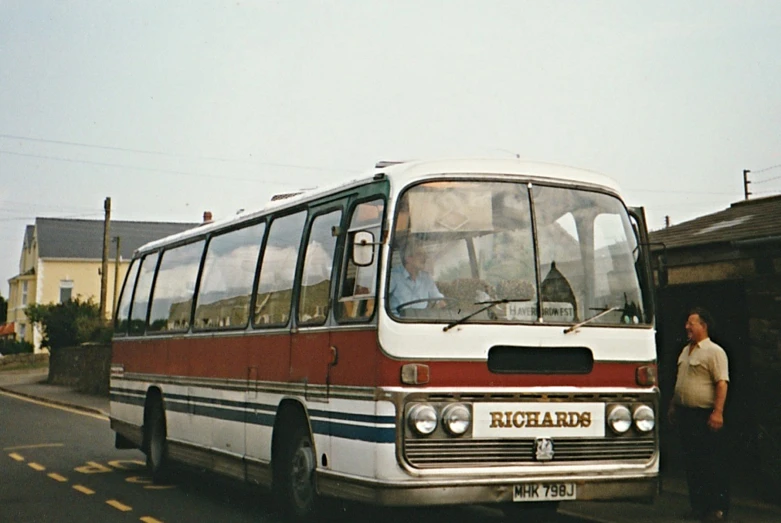 a bus on the side of a road with people standing near it