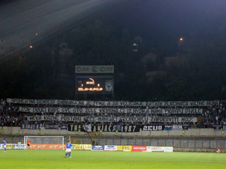 a soccer field at night with banners reading go team