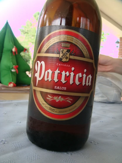 a bottle of beer sitting on a table in front of a christmas tree