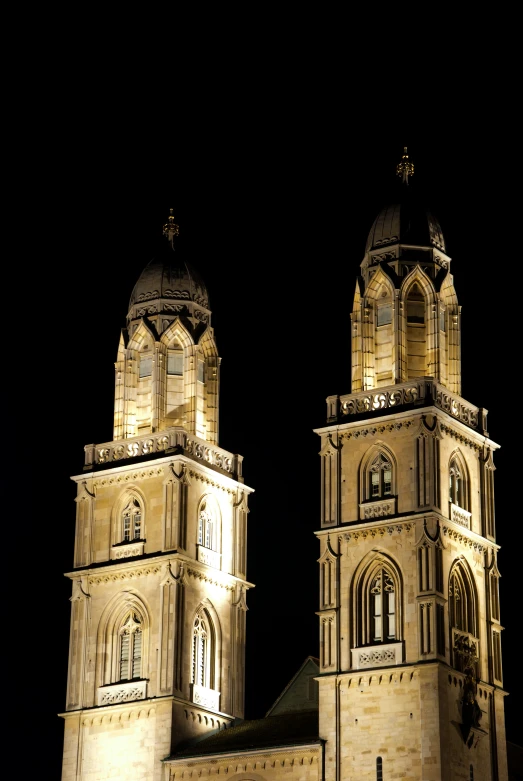 the spires of an old cathedral are lit up at night