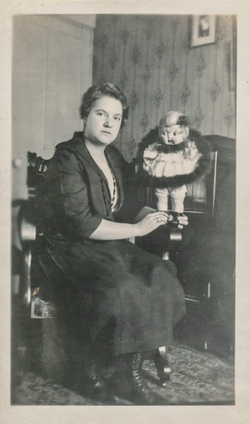 an old fashioned picture of a lady sitting on a chair