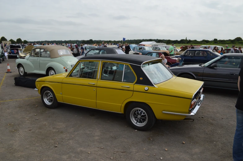 the yellow car is parked in a parking lot