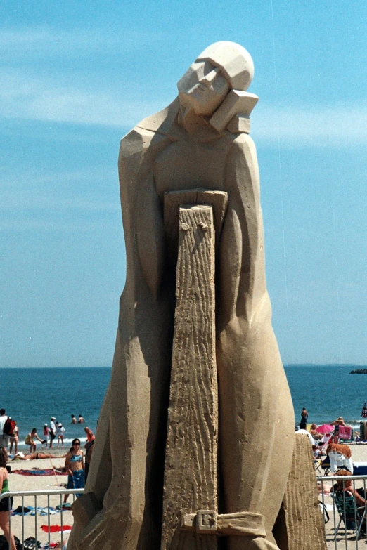 a large sand sculpture of people, sitting and swimming