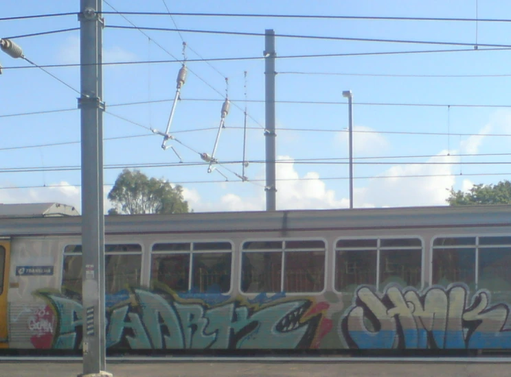 graffiti on the side of a train as it passes through an intersection