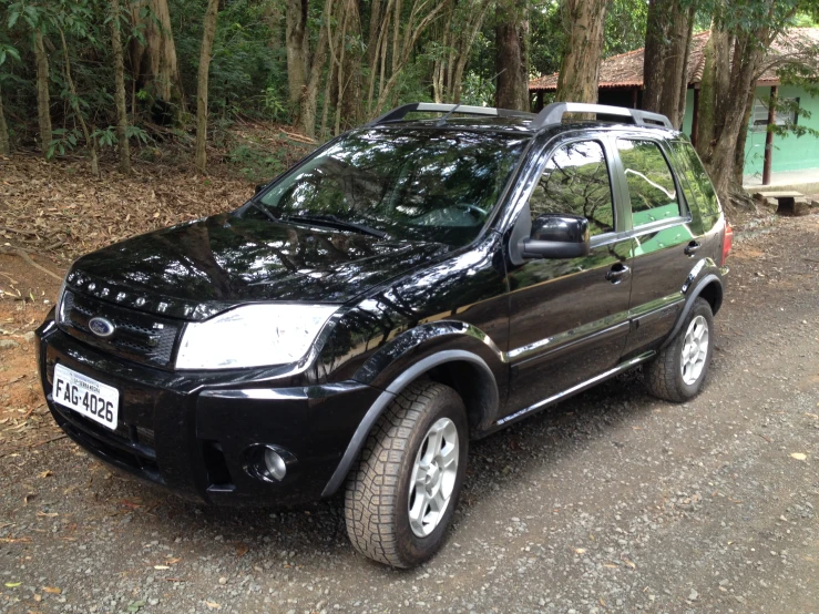 black suv parked in front of a forest area