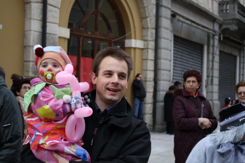 a man with a child in his arms on a street corner