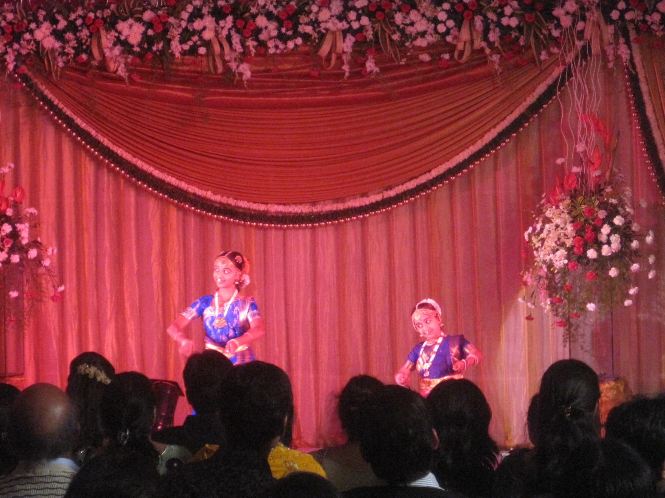 two men on stage speaking in front of a crowd