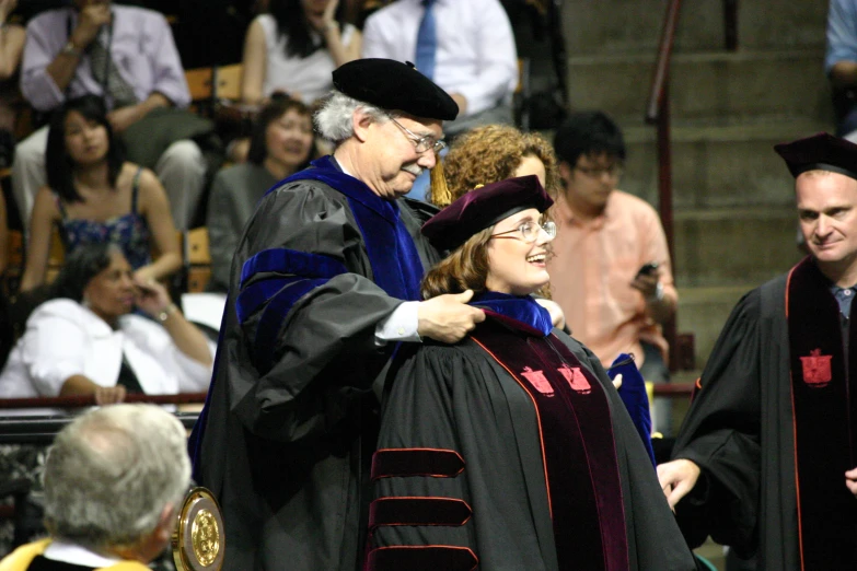 a woman in a large gown smiles while she has her arm around a man's shoulder