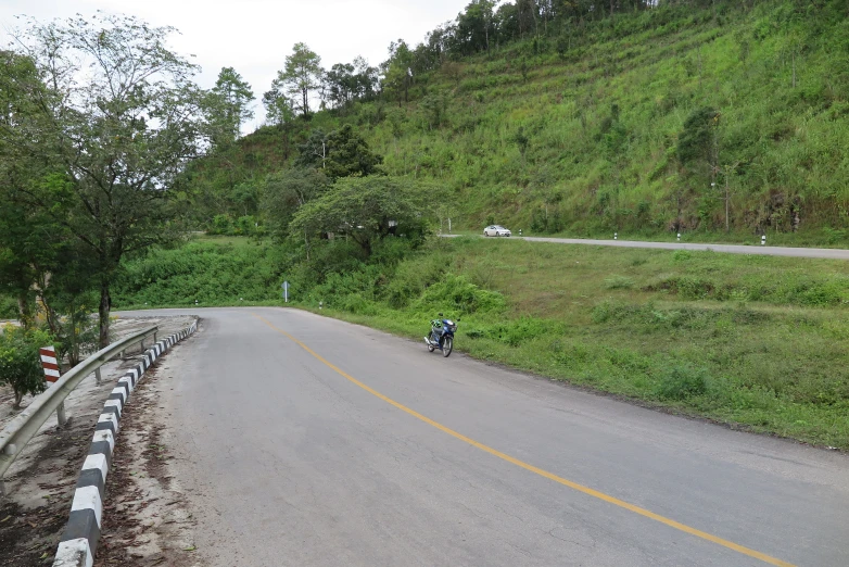 a motorcycle riding on a winding, paved road