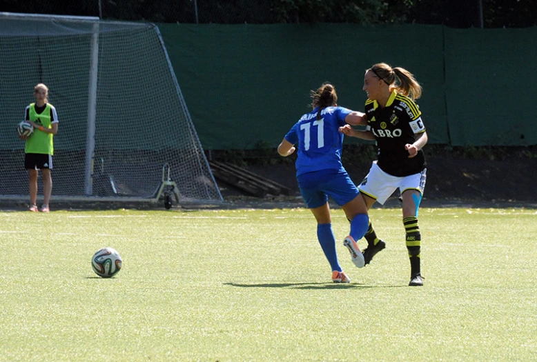 two women on the field playing soccer in a field